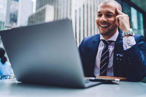 Un empresario investiga en su laptop qué es y cómo invertir en QQQ.