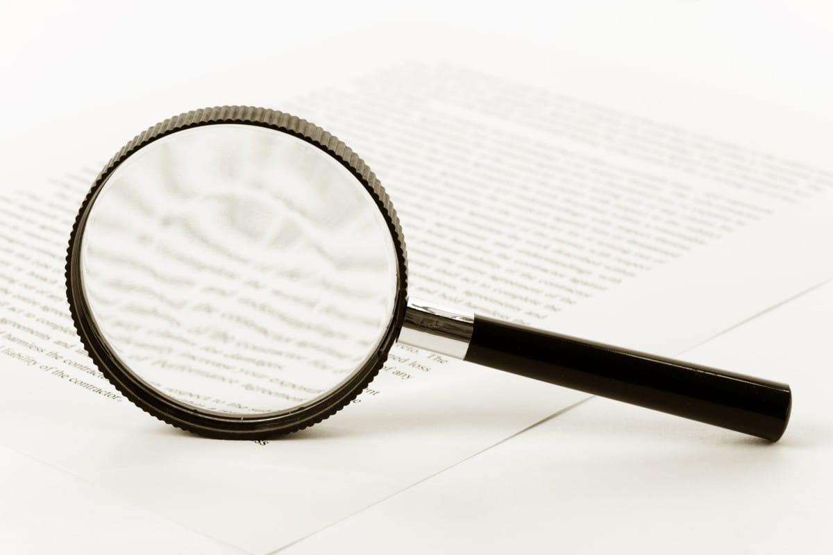 Magnifying glass on a printed document as a symbol of reading legal documents