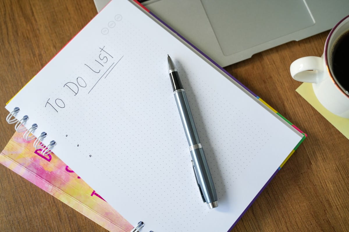Notebook with a handwritten to-do list on a desk