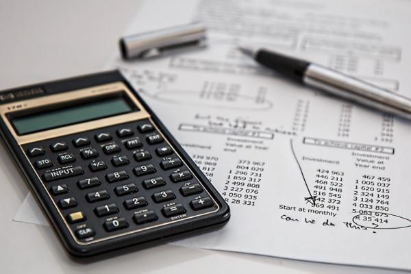 Calculadora y papeles que simbolizan cómo armar un portafolio de inversiones.