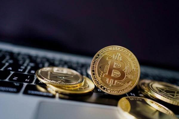  Bitcoins y otras criptomonedas sobre un ordenador. Descubre qué son las feels en la minería crypto.