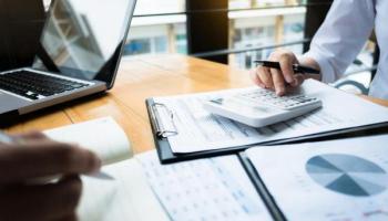 Inversores hacen cuentas con su calculadora y gráficos sobre margen de operación.