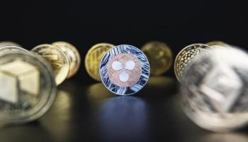 Un ripple y otras crypto sobre una superficie oscura. Con cualquiera de ellas se puede practicar el minado de criptomonedas